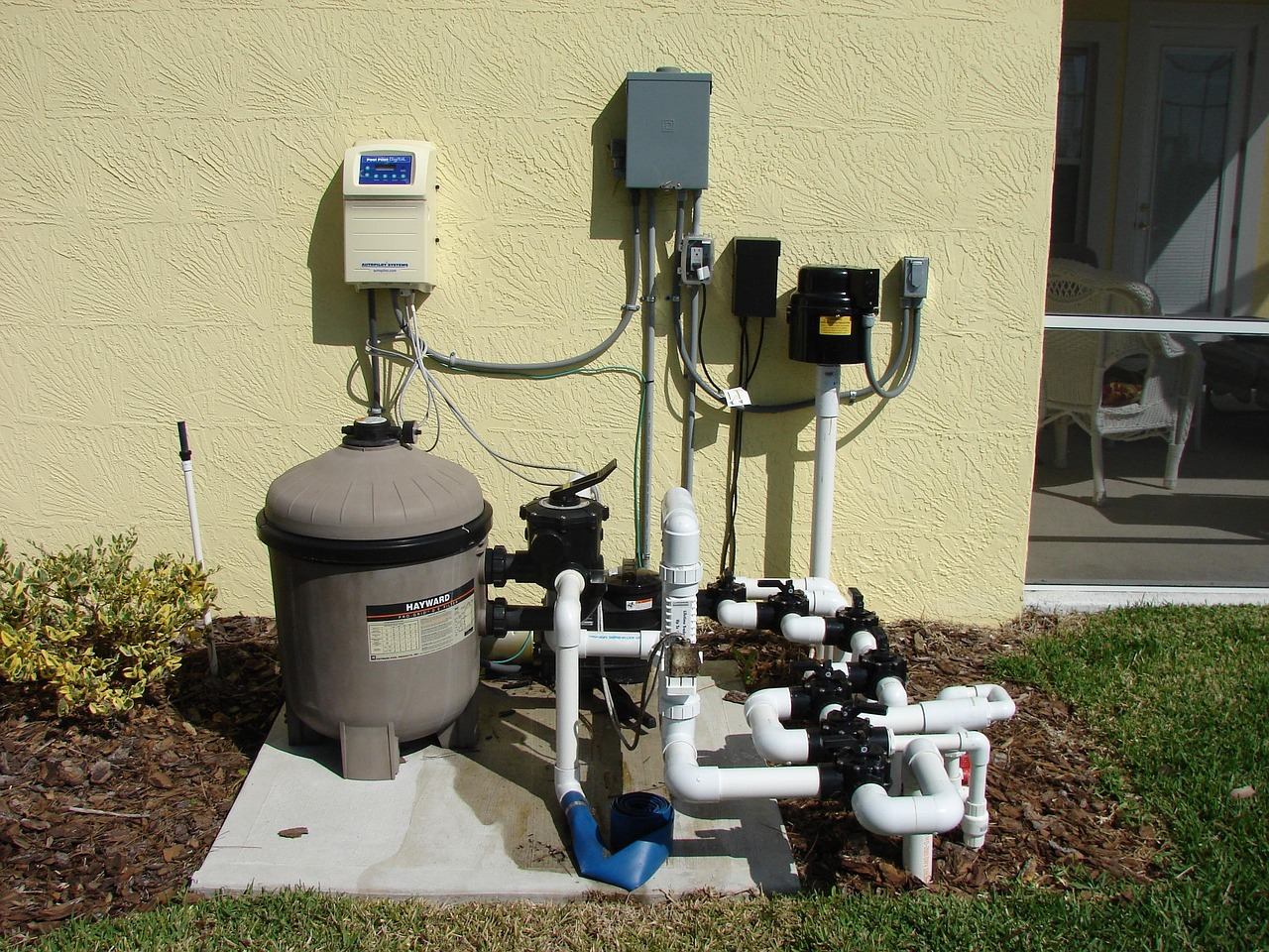 Pool pump and filter equipment beside a swimming pool